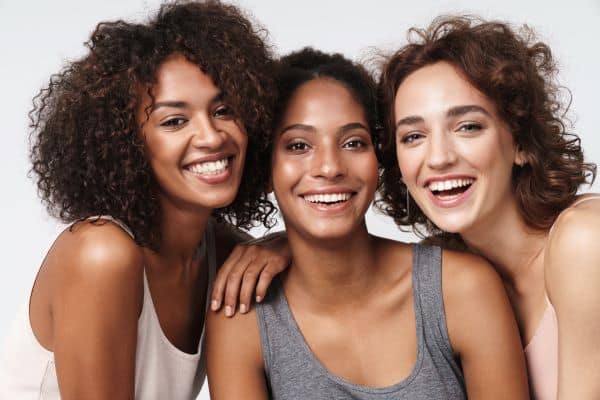 A group of three young women smiling and posing together