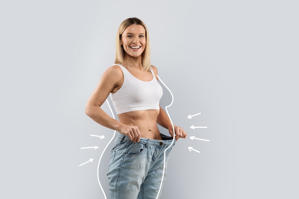 A woman holding her jeans away from her waist after GLP-1 weight loss injections in Sevierville